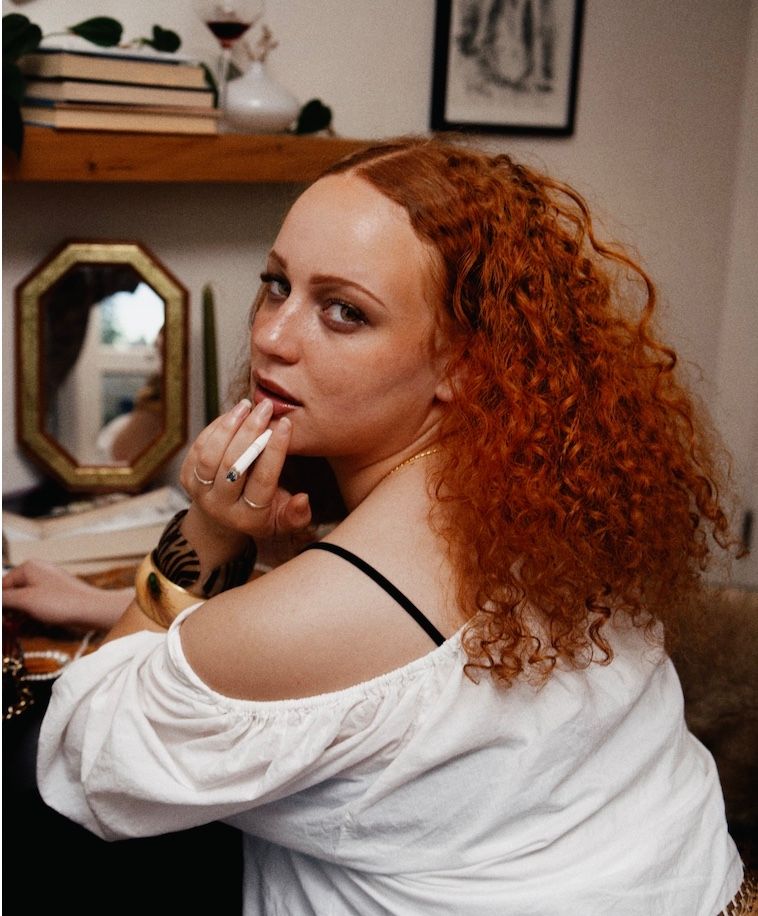 Copper red natural curls, shoulder length, in an editorial portrait